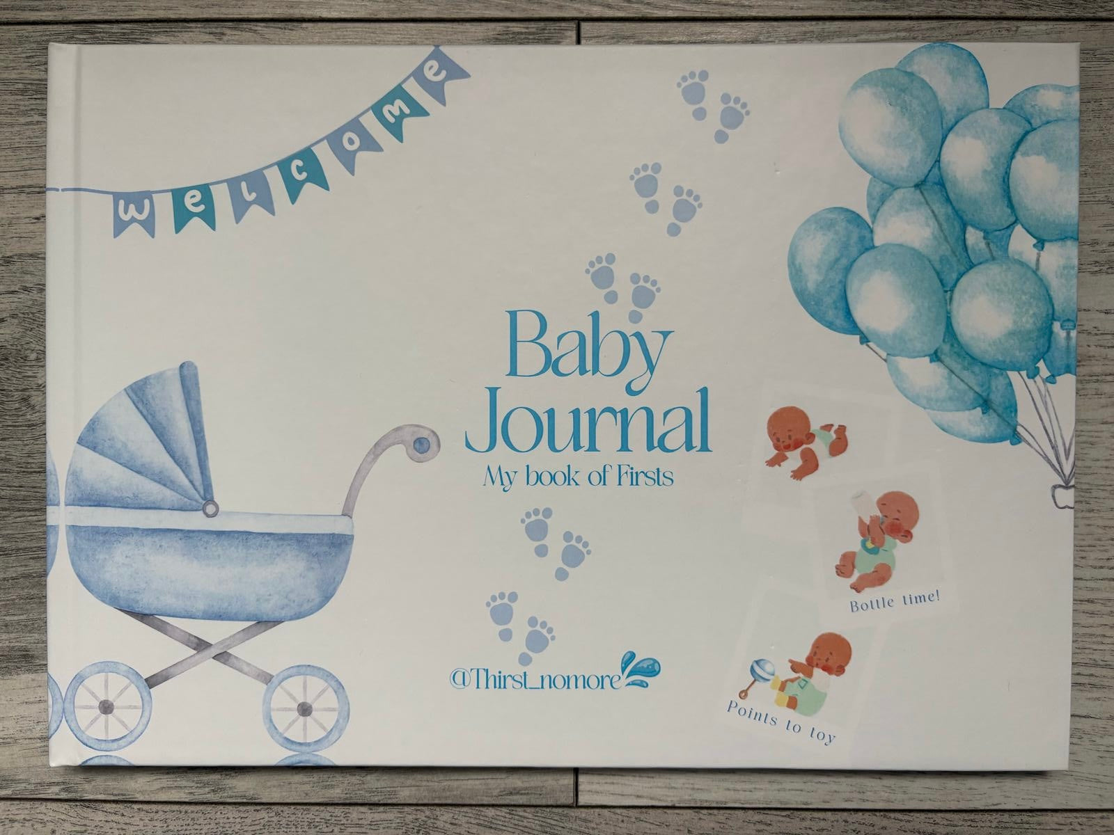 Cover of a boys 'Baby Journal' featuring illustrations of a baby carriage, balloons, and decorative elements in blue color on a white background.